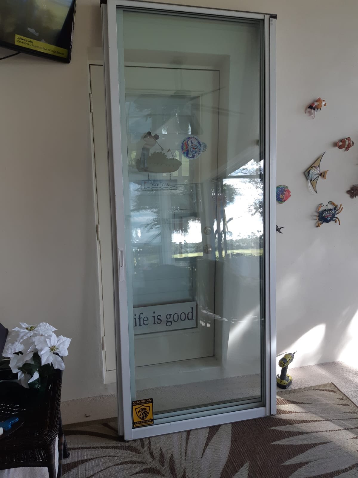 Replacement sliding door glass panel re-installed in aluminum frame — Guardian impact sticker confirms new unit, South Florida